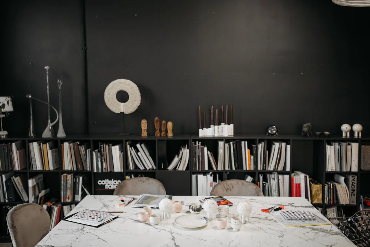 Elegant conference room featuring a marble table, black bookshelves, and stylish decor elements.